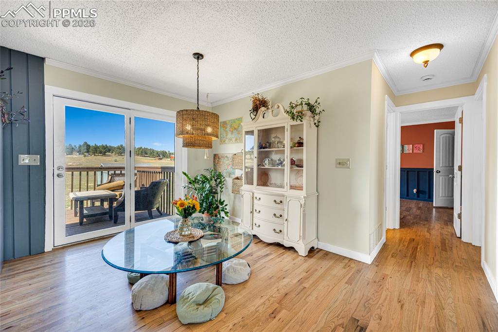 Image 10 of 42: This room features hardwood floors and a glass door that opens to an outdoo