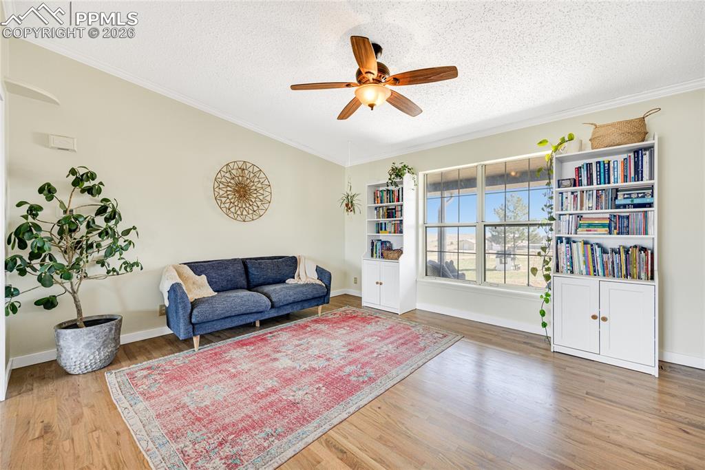 Image 12 of 42: This spacious living area features hardwood floors and a ceiling fan, enhan