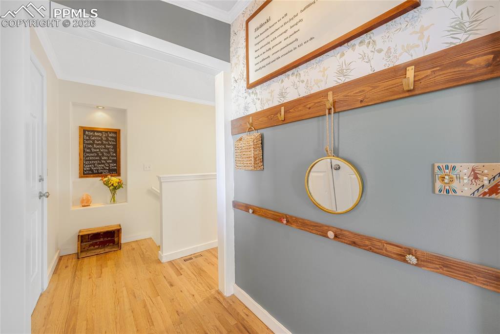 Image 15 of 42: The property features a foyer with hardwood flooring and feature wall