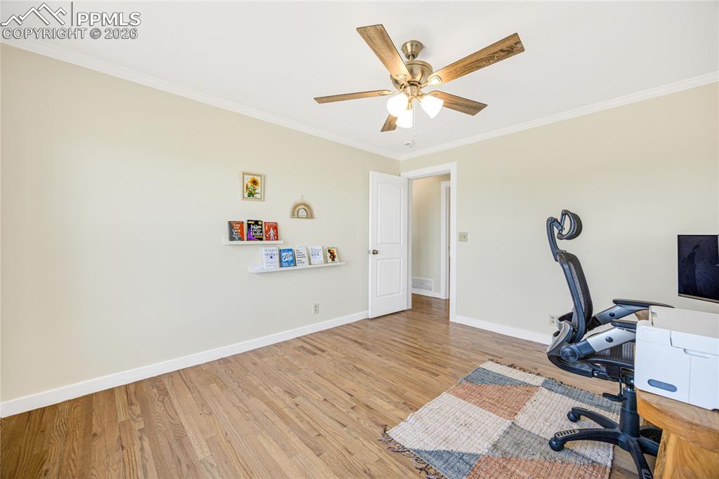 Image 20 of 42: This room features hardwood flooring, light-colored walls, and a ceiling fa