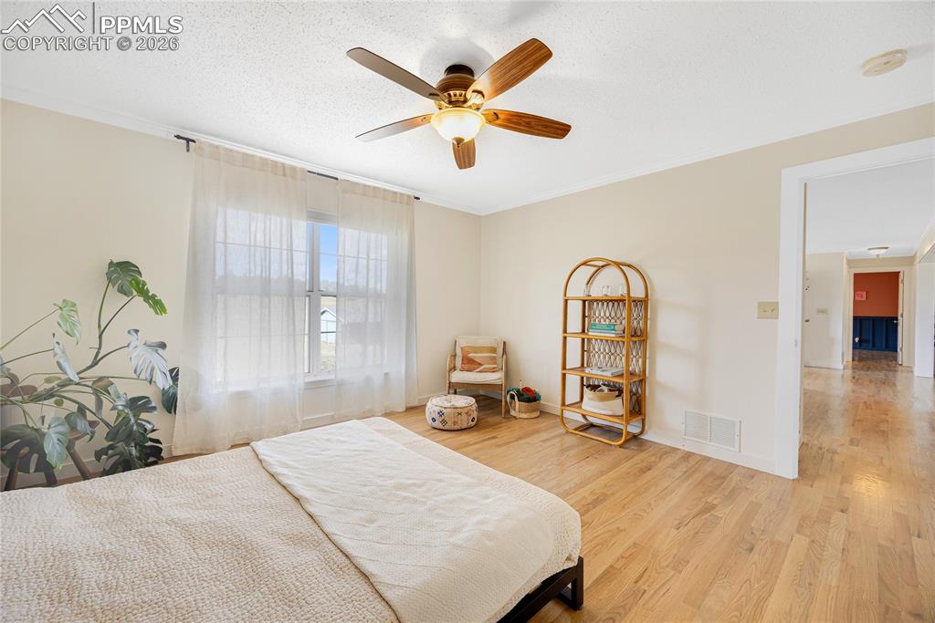 Image 22 of 42: This spacious room features hardwood flooring, a ceiling fan with integrate