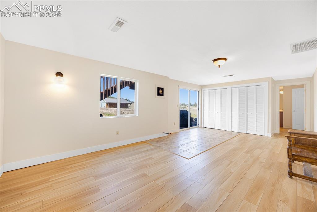 Image 25 of 42: Spacious interior with light-toned walls, LVP flooring, and a large window 