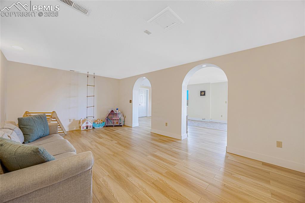 Image 27 of 42: Spacious interior room featuring light-colored flooring, neutral wall paint