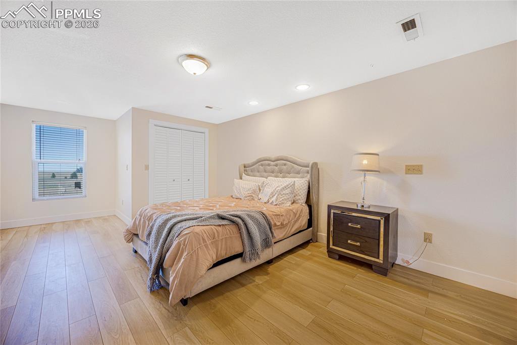 Image 28 of 42: This bright room features light-toned flooring, a window with horizontal bl