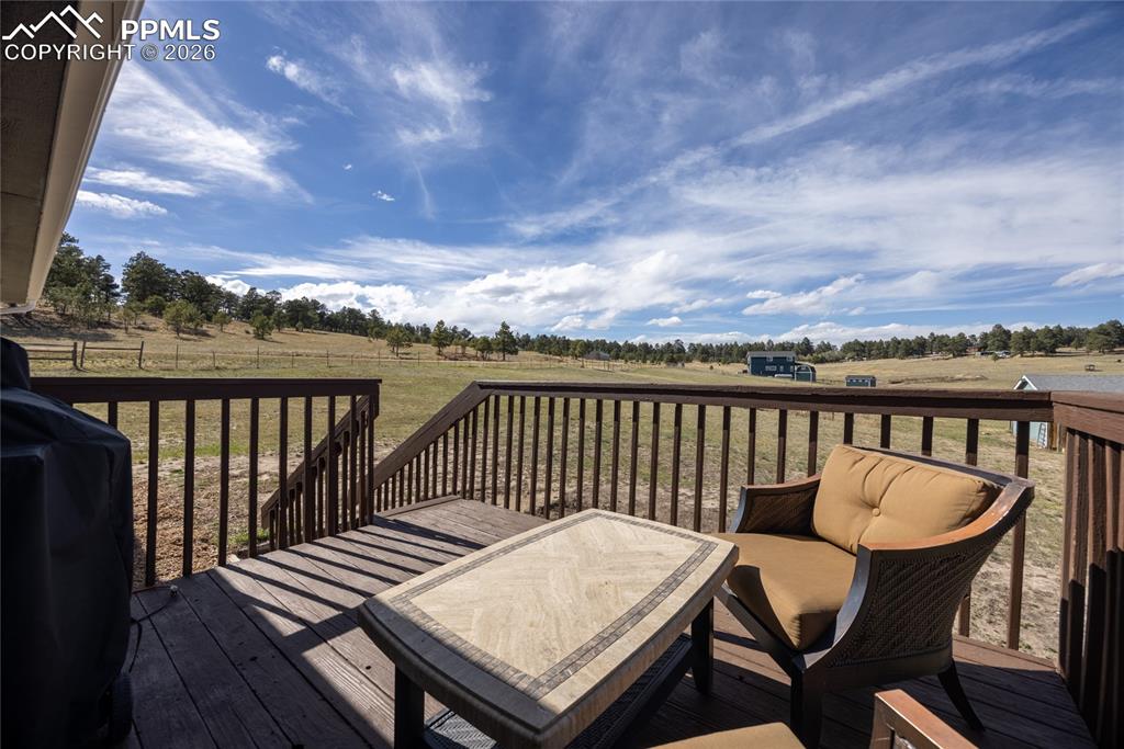 Image 33 of 42: The property features an outdoor deck with wood railing, offering expansive