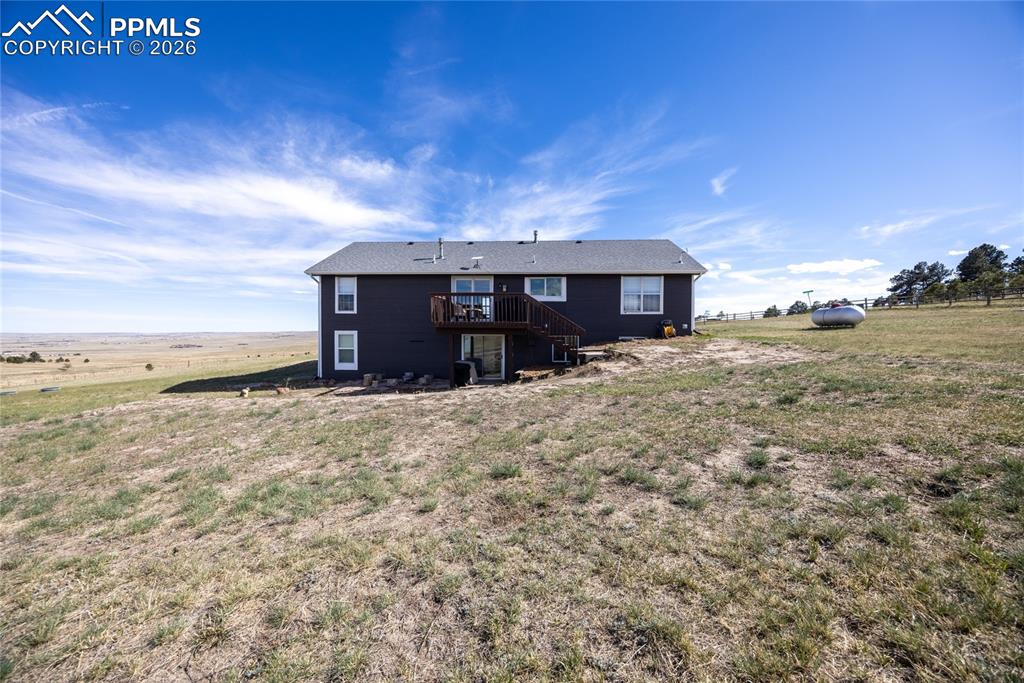 Image 34 of 42: The property features an exterior with dark siding, a deck, and a walk-out 