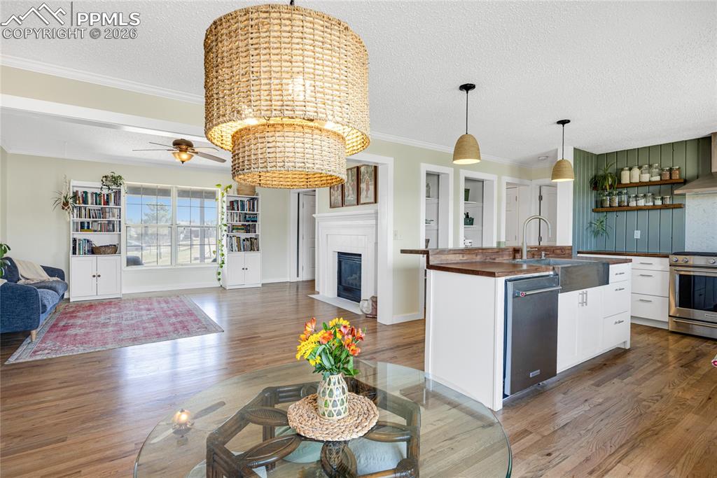 Image 6 of 42: Spacious open-concept living area featuring hardwood flooring, a fireplace 