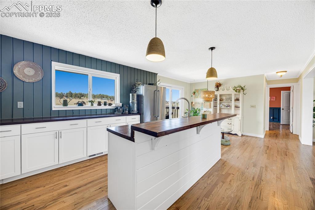 Image 9 of 42: The property features hardwood flooring throughout, white cabinetry with da