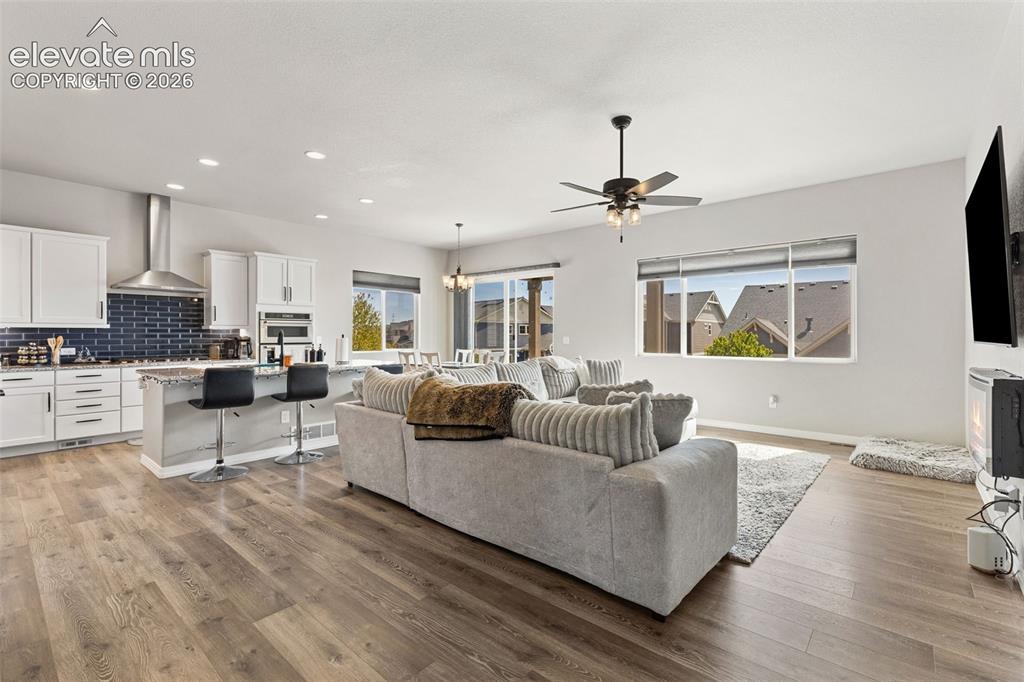 Image 14 of 44: Open-concept living space featuring wood-finish flooring, recessed lighting