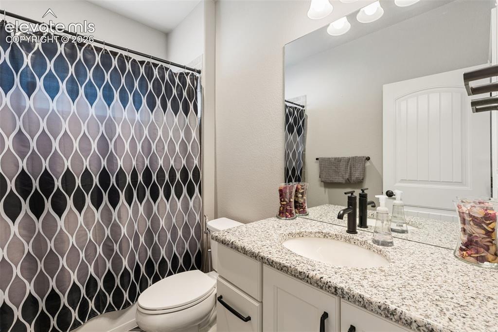 Image 23 of 44: Bathroom featuring a vanity with a light granite countertop, an undermount