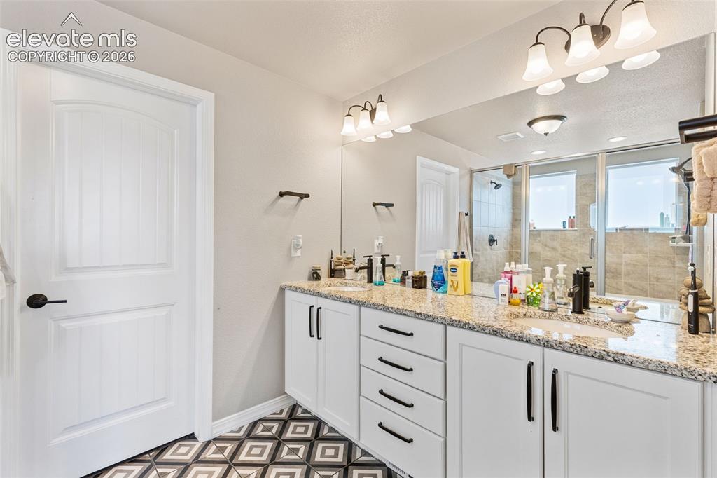 Image 32 of 44: Dual vanity featuring granite countertops with undermount sinks, white cabi