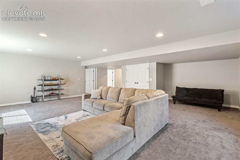Image 36 of 44: Spacious room featuring neutral carpeting, light gray walls, recessed light