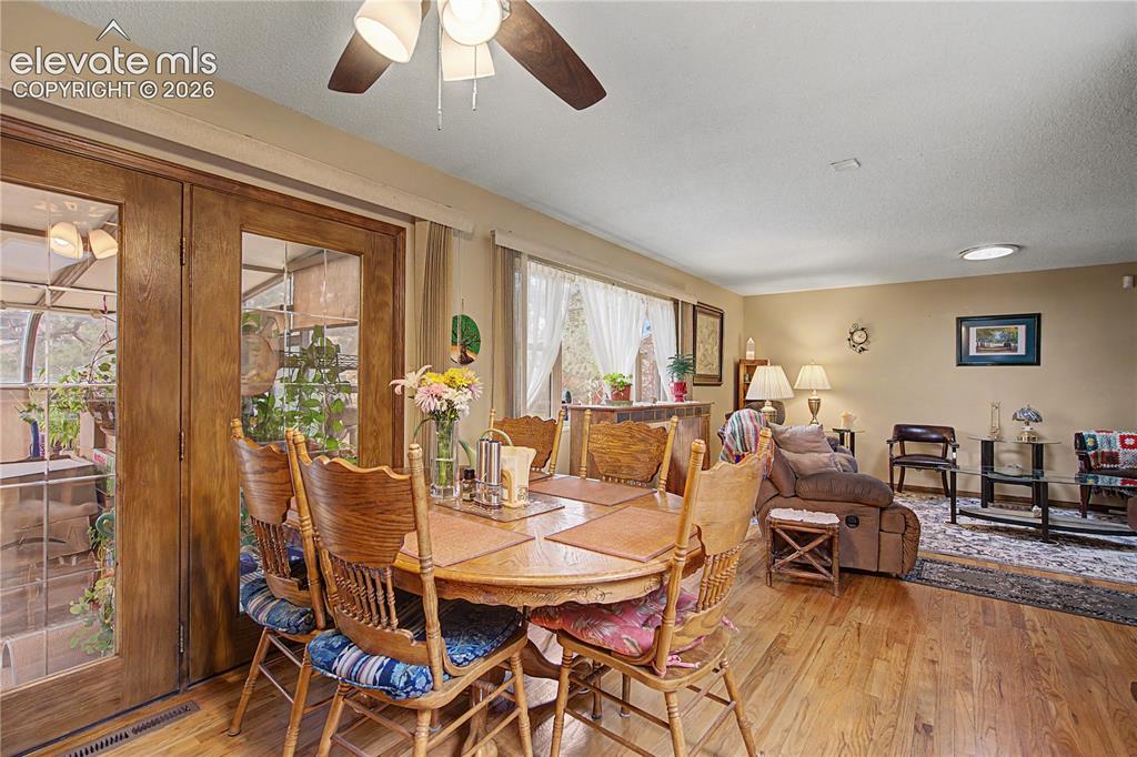 Image 10 of 38: Open-concept dining and living area featuring wood-finish flooring, a ceili