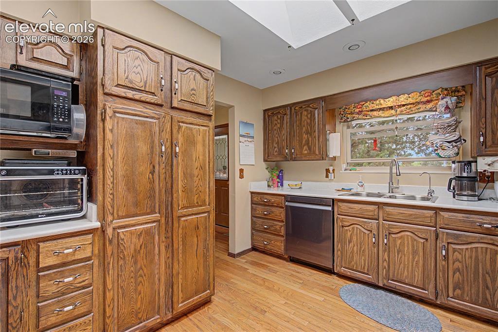 Image 12 of 38: Kitchen featuring extensive wood cabinetry, wood-finish flooring, a stainle