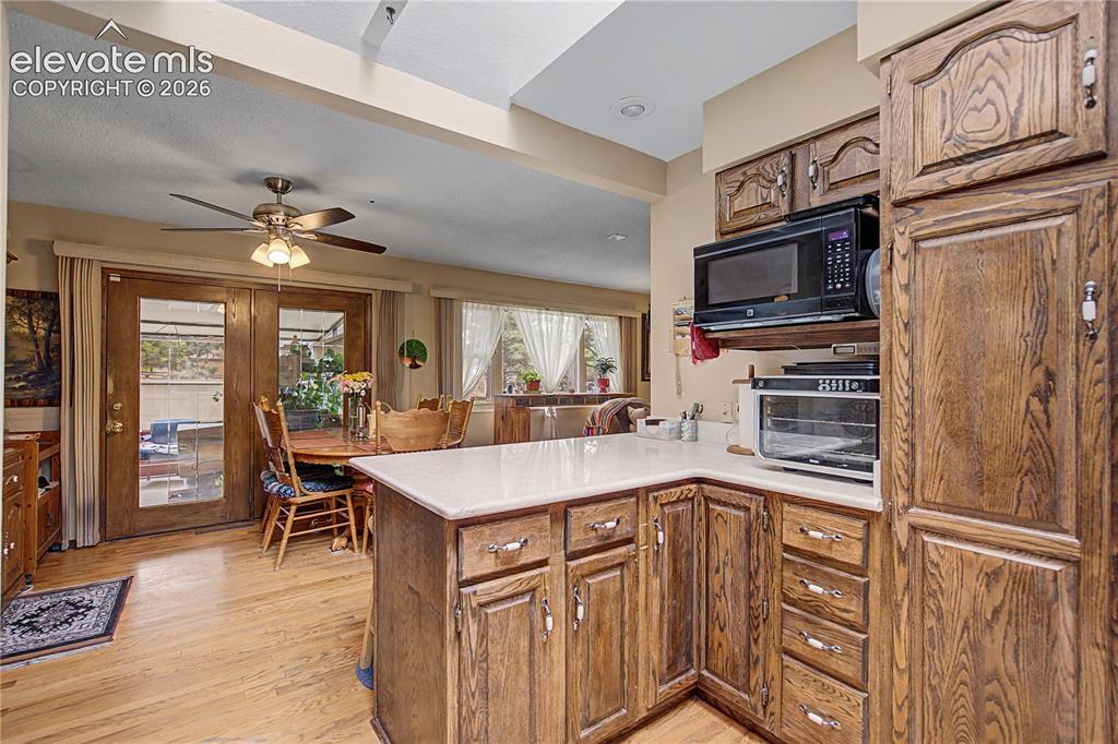 Image 15 of 38: Kitchen featuring wood-finish cabinetry, light-toned countertops, and a bui
