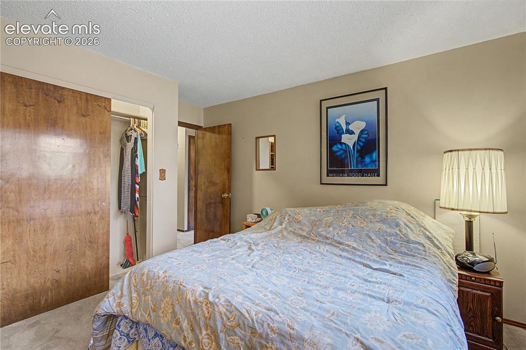 Image 18 of 38: Bedroom featuring neutral tone walls, textured ceiling, and light-colored c