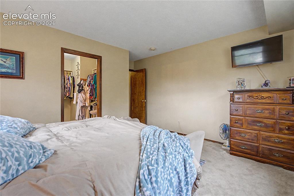 Image 23 of 38: Carpeted sleeping area featuring a recessed closet with wood trim and a sep