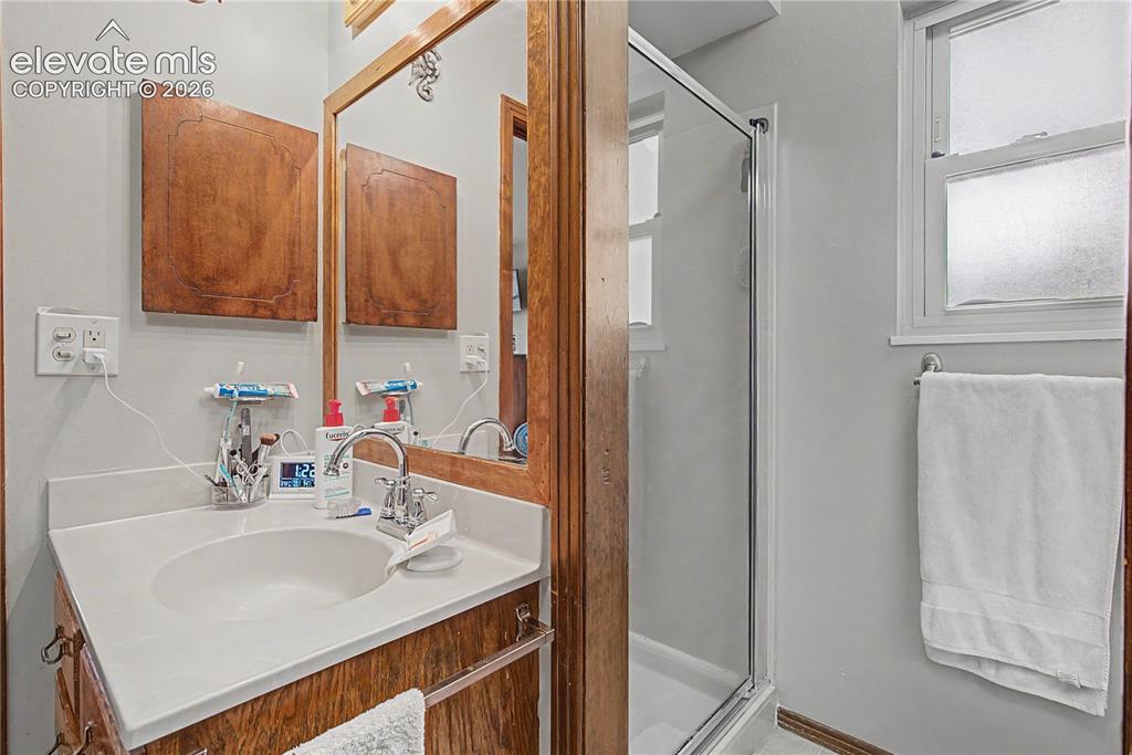 Image 25 of 38: Bathroom featuring a wood-framed mirror, a single vanity with an integrated