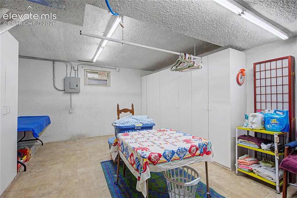 Image 31 of 38: Utility room with white walls, fluorescent ceiling lighting, and light-tone