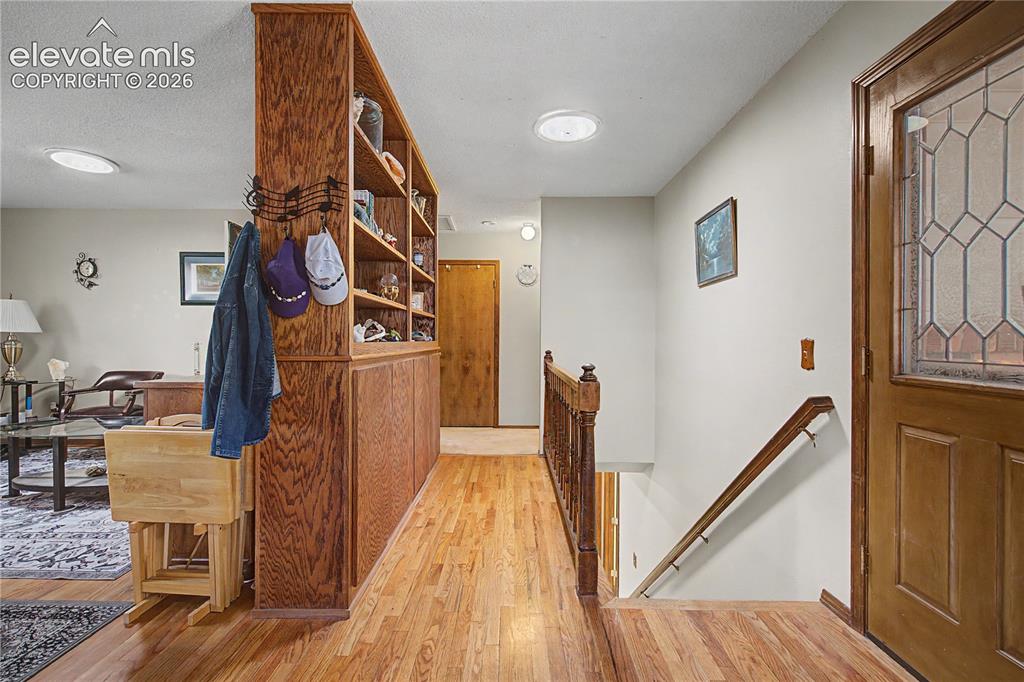 Image 4 of 38: Entryway featuring hardwood flooring, a built-in shelving unit with wood pa