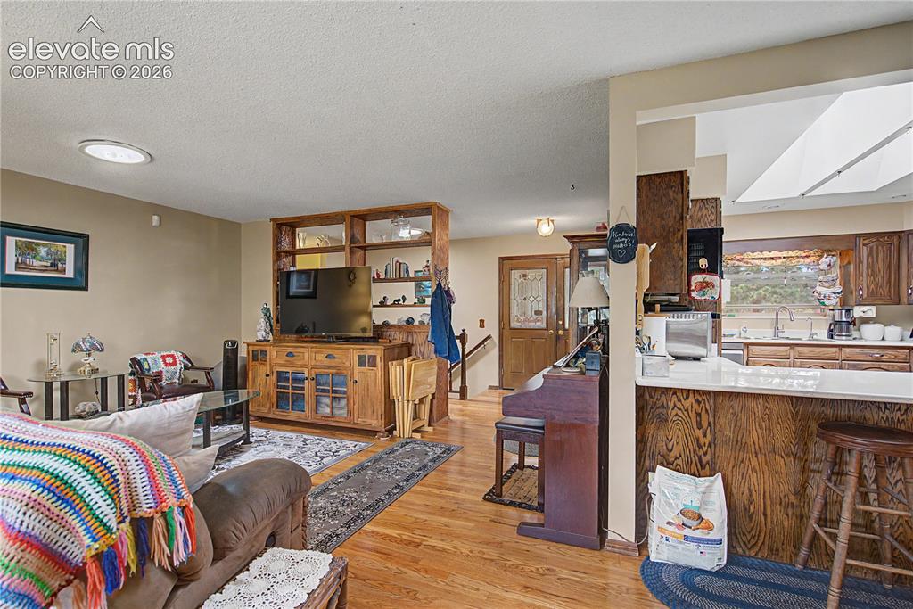 Image 7 of 38: Open concept living area with wood-finish flooring