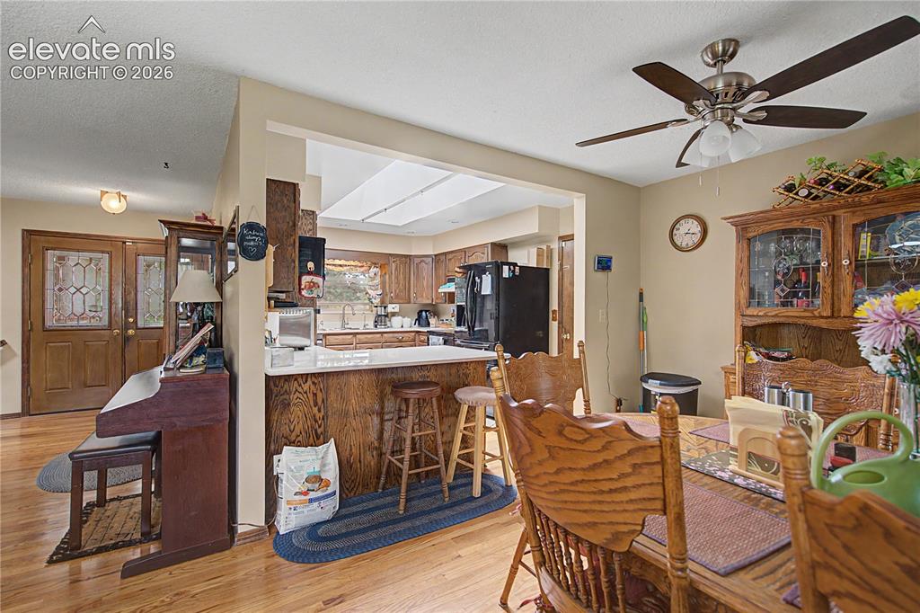 Image 8 of 38: Dining area featuring wood-finish flooring, a ceiling fan with integrated l