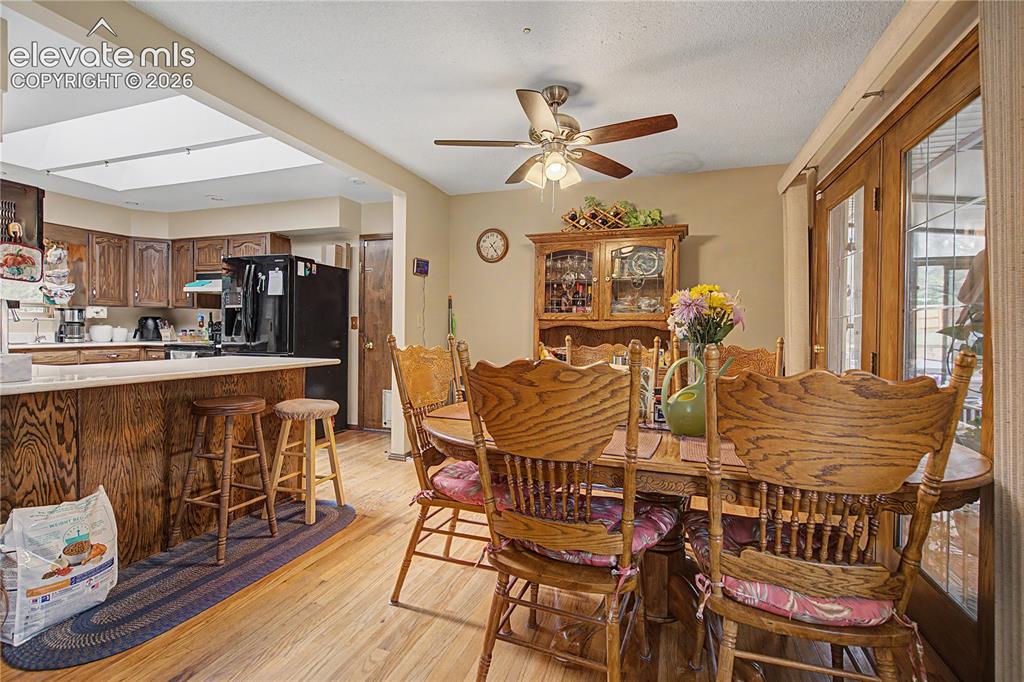 Image 9 of 38: Dining area featuring wood-finish flooring, a ceiling fan with integrated l