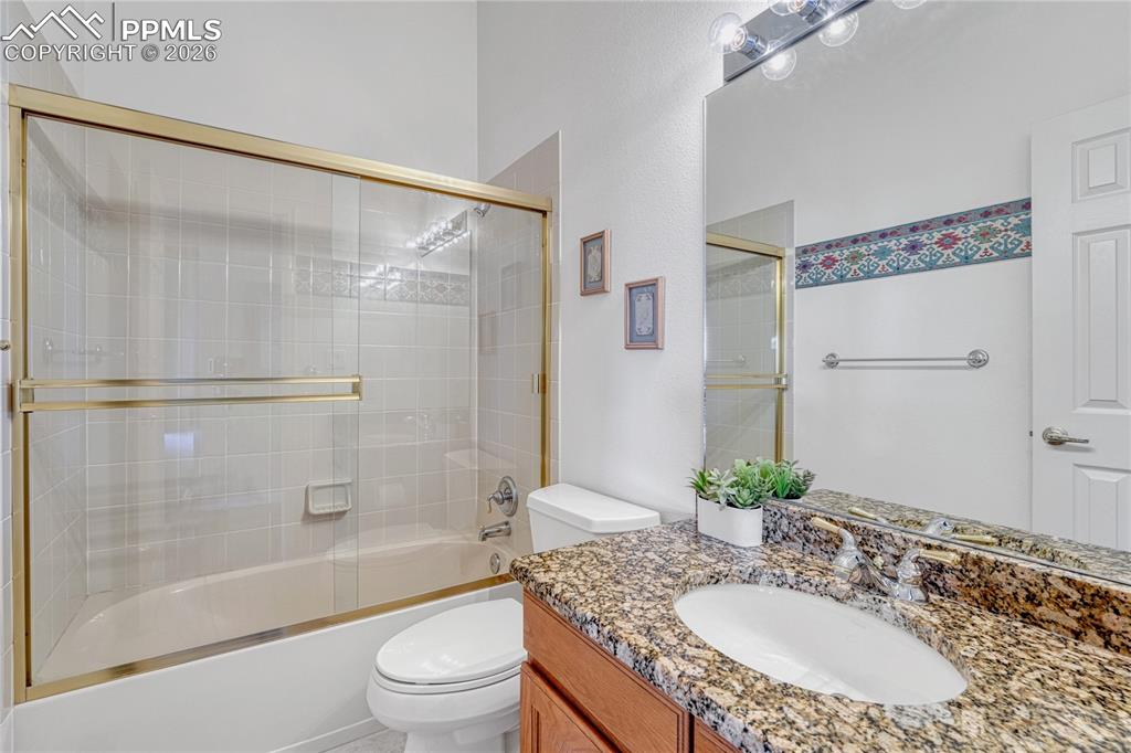 Image 25 of 50: Full bath on main level with granite countertop and tile floor. 