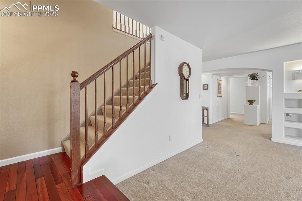 Image 29 of 50: Stairs with hardwood floor landing to the...