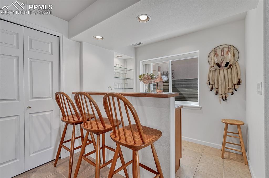 Image 41 of 50: Wet bar offers natural light, bar fridge and sink. 