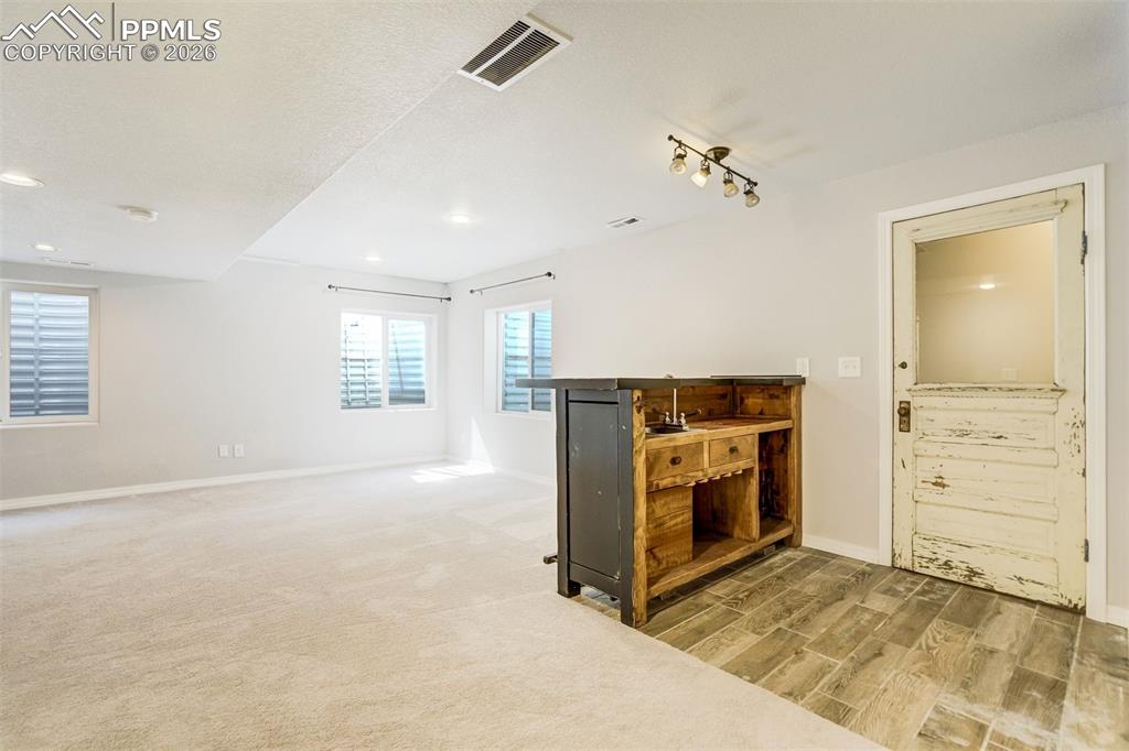 Image 36 of 45: Wet bar area with an antique door that leads to closet storage.