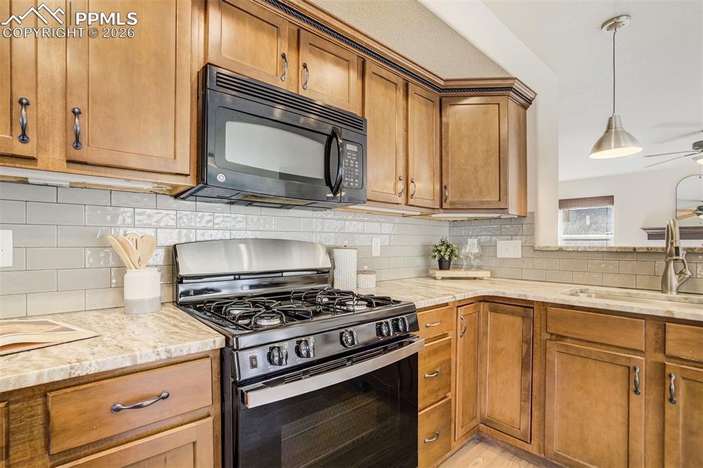 Image 9 of 45: Stone counters with a brand new gas range.