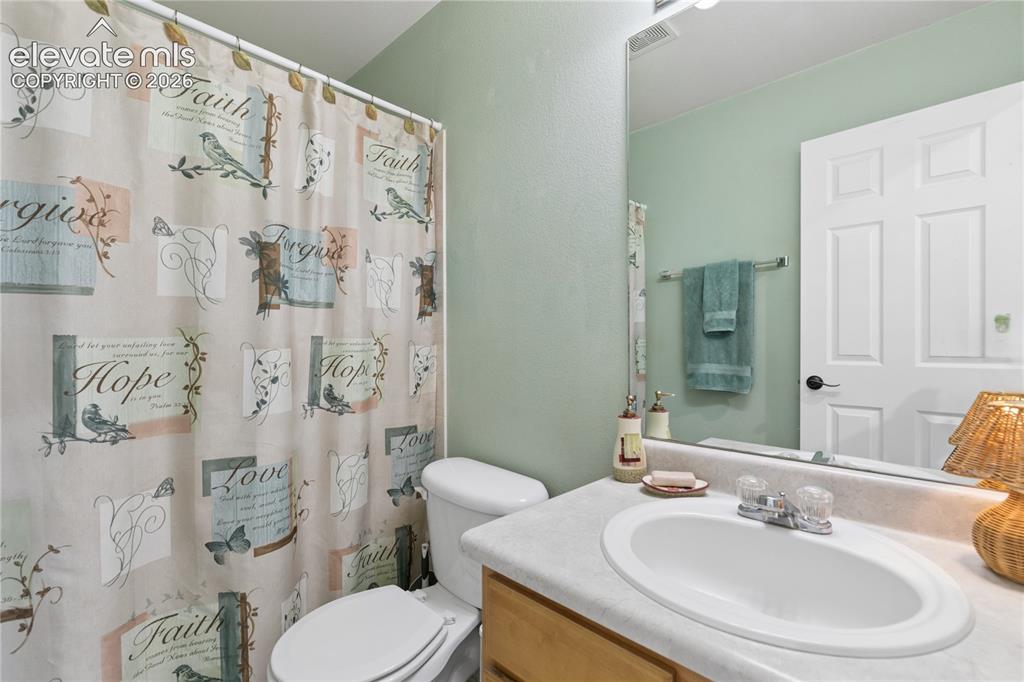 Image 14 of 35: White paneled door, light wood-finish vanity, integrated sink, wall-mounted