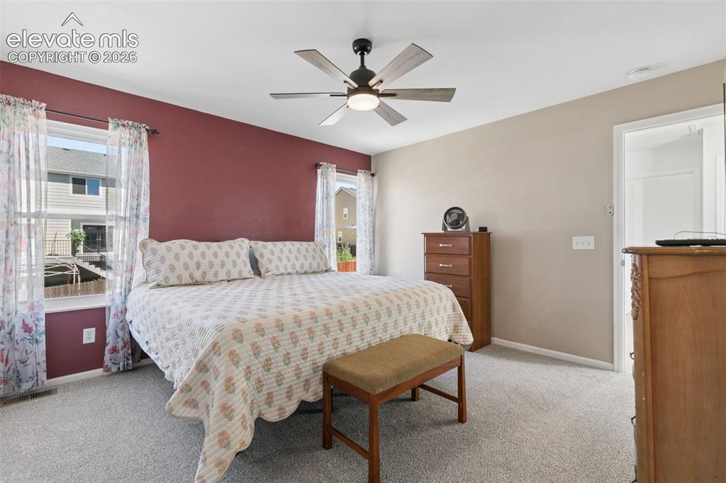 Image 25 of 35: Ceiling fan with integrated lighting, dual windows, neutral-toned carpeting