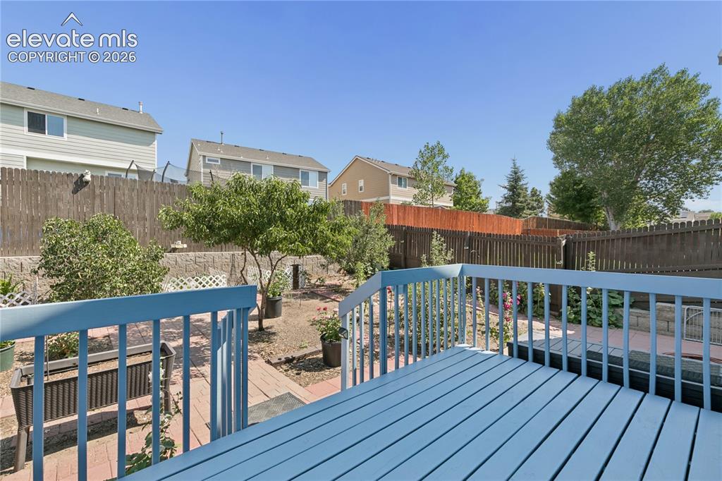 Image 27 of 35: Expansive outdoor deck with painted wood planks, leading to a backyard feat