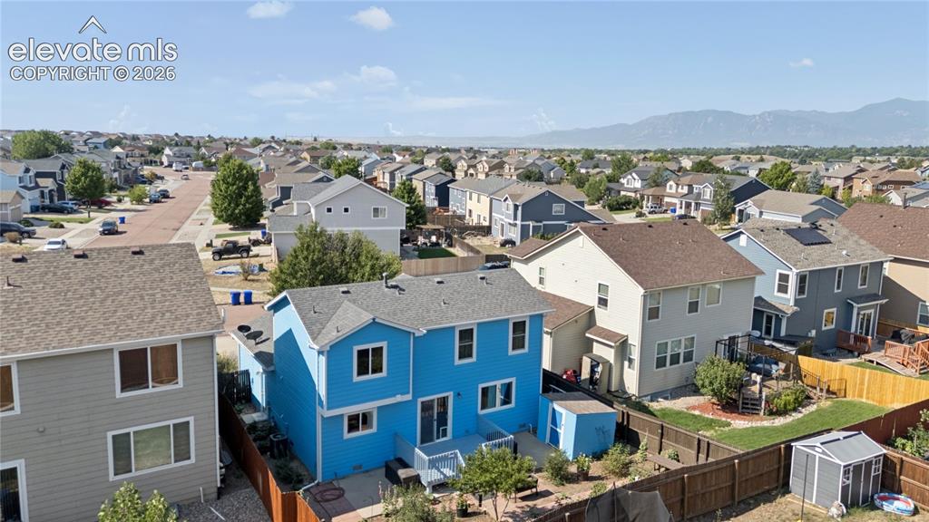 Image 32 of 35: Residential structure with a blue siding exterior, a gray shingle roof, and
