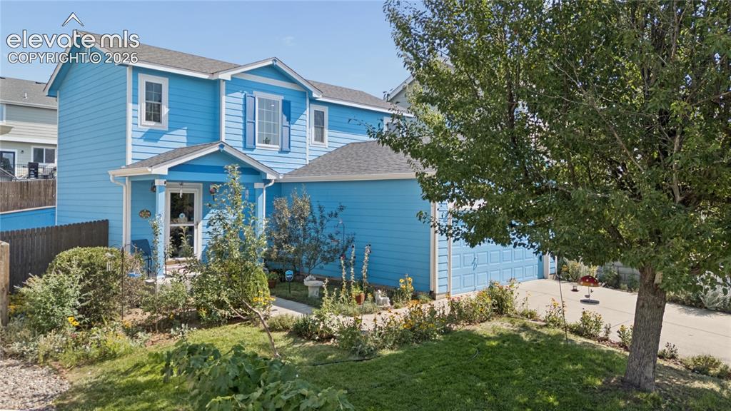 Image 35 of 35: Two-story residence with a covered entryway, attached two-car garage, and a