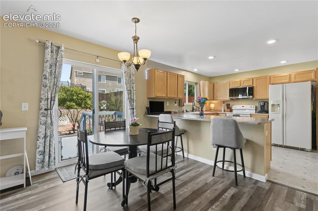 Image 8 of 35: Wood-finish flooring, recessed lighting, wood cabinetry, built-in microwave