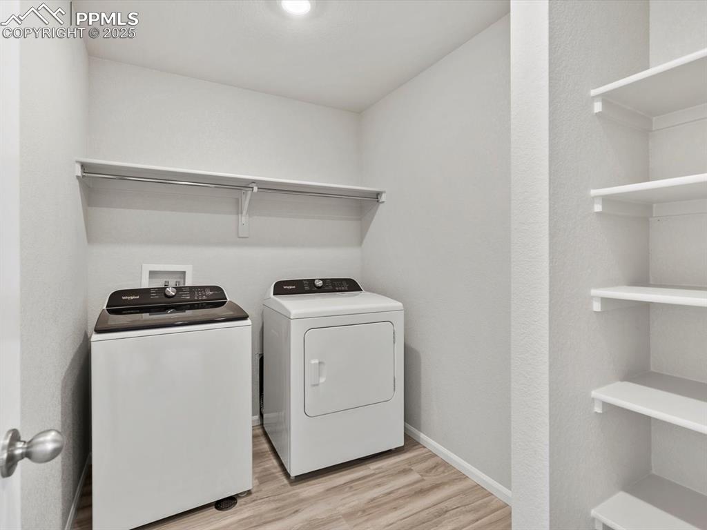 Image 10 of 22: Laundry area featuring separate washer and dryer and light wood-style floor