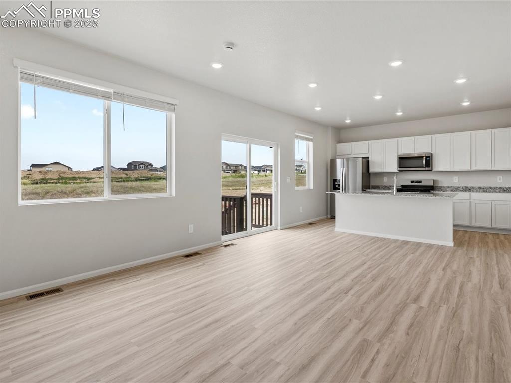 Image 5 of 22: Unfurnished living room with light wood-style floors and recessed lighting