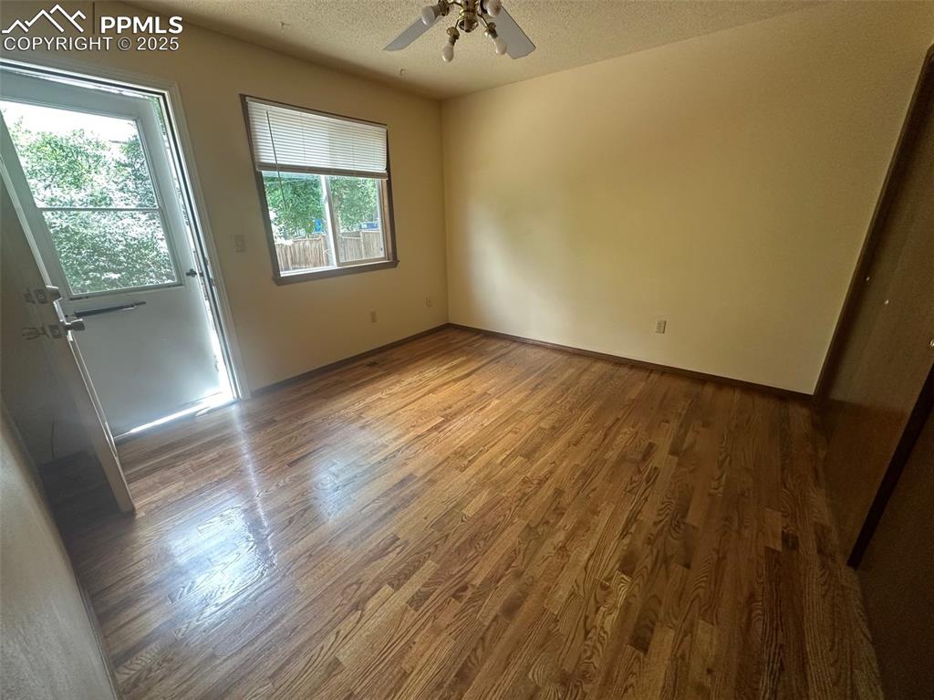Image 11 of 22: Main bedroom with wood finished floors, a ceiling fan, and a textured ceili
