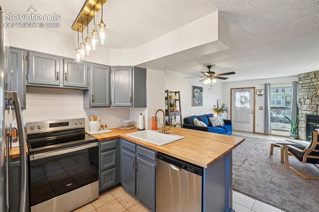 Image 10 of 24: Kitchen featuring wood-finish countertops, grey cabinetry, and stainless st