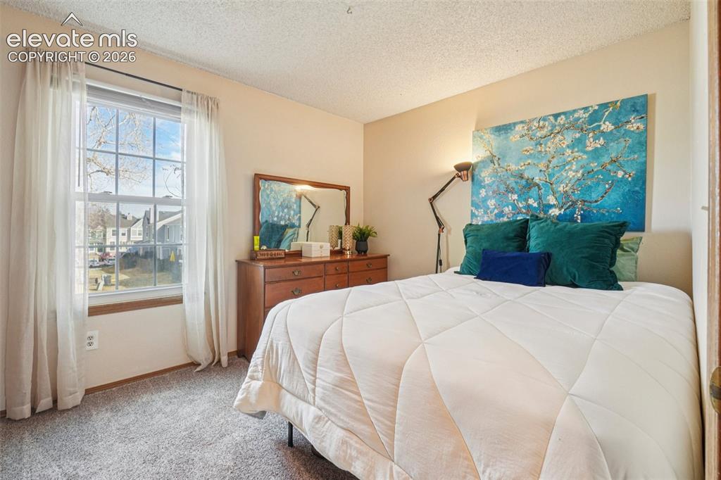 Image 14 of 24: Bedroom featuring light-toned wall paint and textured ceiling