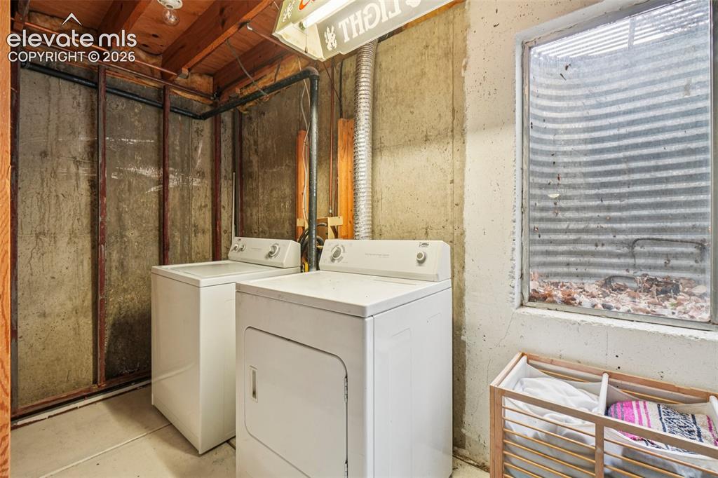 Image 19 of 24: Dedicated laundry area featuring a window, exposed wood ceiling joists, con