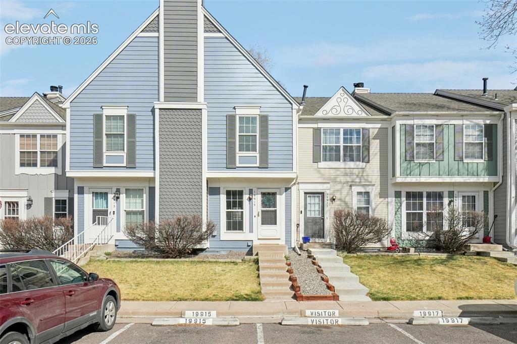 Image 4 of 24: Townhome exterior featuring blue siding, white trim, a gabled roofline, and