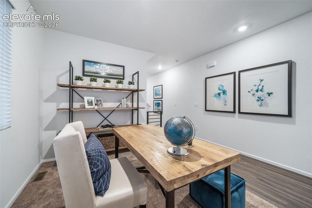 Image 13 of 41: Recessed lighting, wood-finish flooring, and built-in shelving with a metal