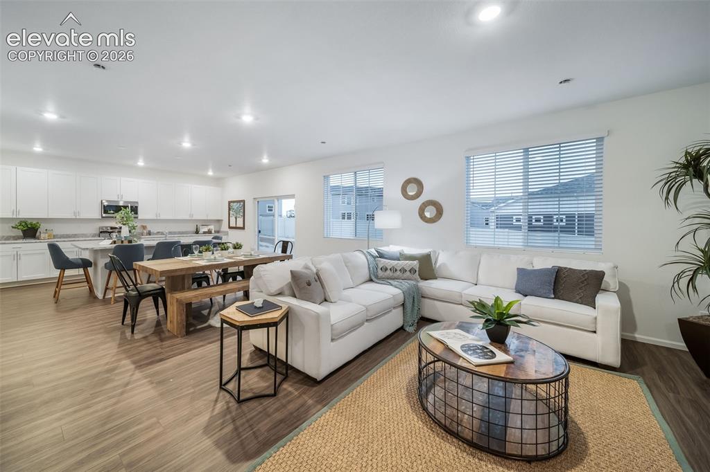 Image 19 of 41: Open-concept living area featuring wood-finish flooring, white cabinetry, a