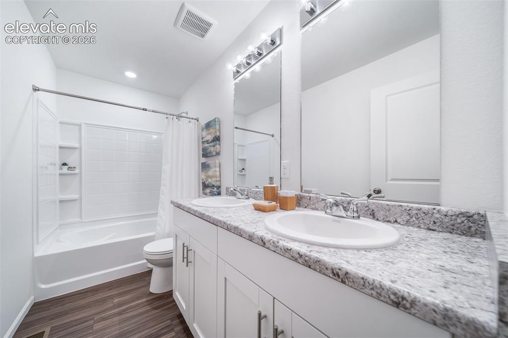 Image 21 of 41: Dual vanity with white cabinetry, light-toned countertop, and undermount si