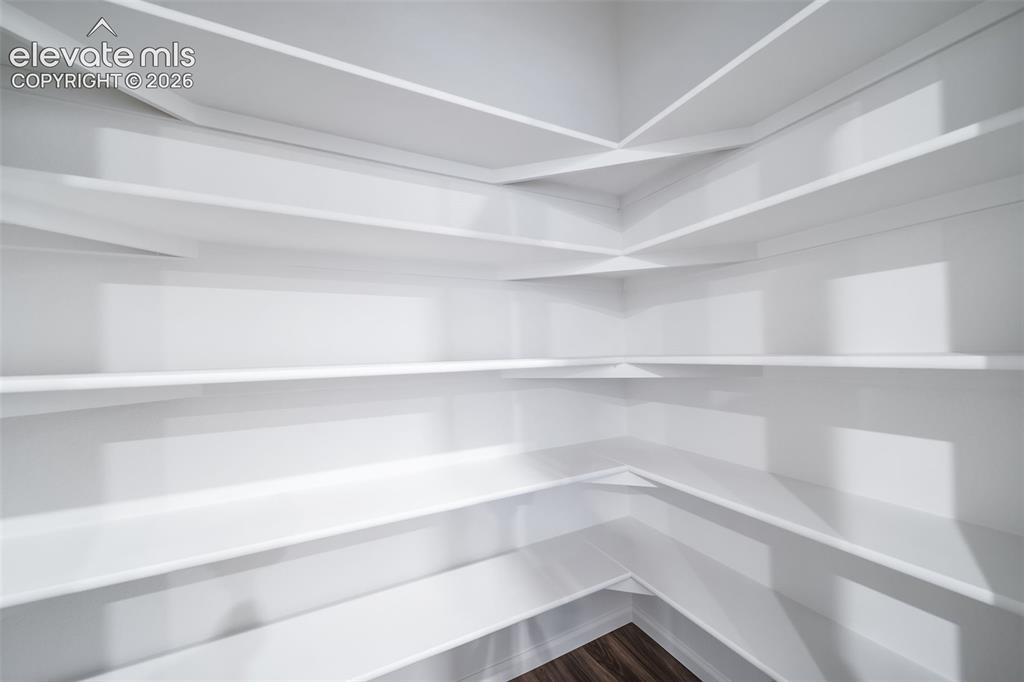 Image 30 of 41: Built-in shelving with white finishes and dark wood-finish flooring
*photo