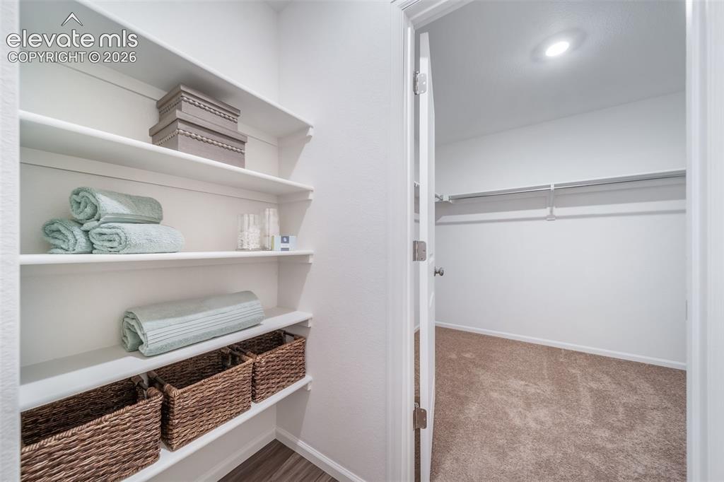 Image 33 of 41: Built-in shelving with wood-finish flooring, accompanied by an additional c
